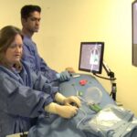 Iris Grunwald (left) demonstrates the use of a surgical simulator featured